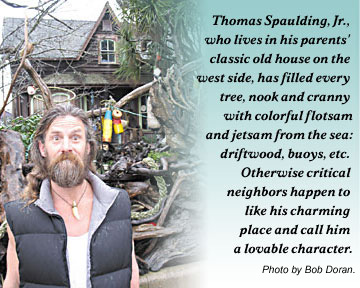 Photo of Thomas Spaulding Jr., who lives in his parents' classic old house on the west side, has filled every tree, nooka nd cranny with colorful flotsam and jetsam from teh sea: driftwood, buyoys, etc. Otherwise critical neighbors happen to like his charming place and call hima a lovable character. Photo by Bob Doran.